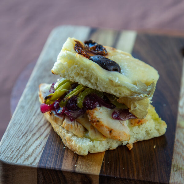 Focaccia de olivas negras, pollo braseado, cebollas y morrones asados