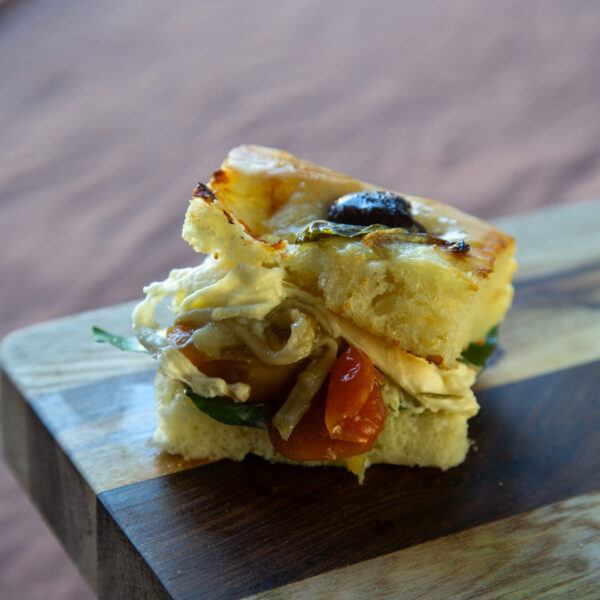 Focacciade olivas negras. berenjena ahumada, burrata, tomates secos, espinaca