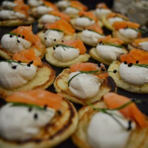 Blinis, salmón gravlax, crema de hierbas, sesamo