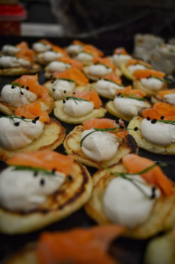 Blinis, salmón gravlax, crema de hierbas, sesamo
